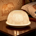 Decorative asian elephant tea light holder with elephant design on a bedside table.