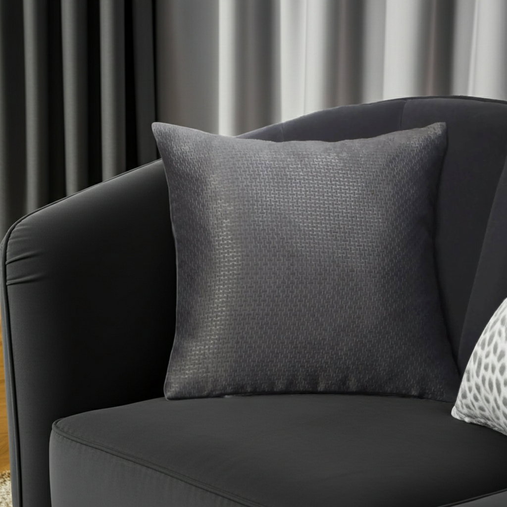 Gray textured basket weave cushion on a black armchair with gray curtains in the background