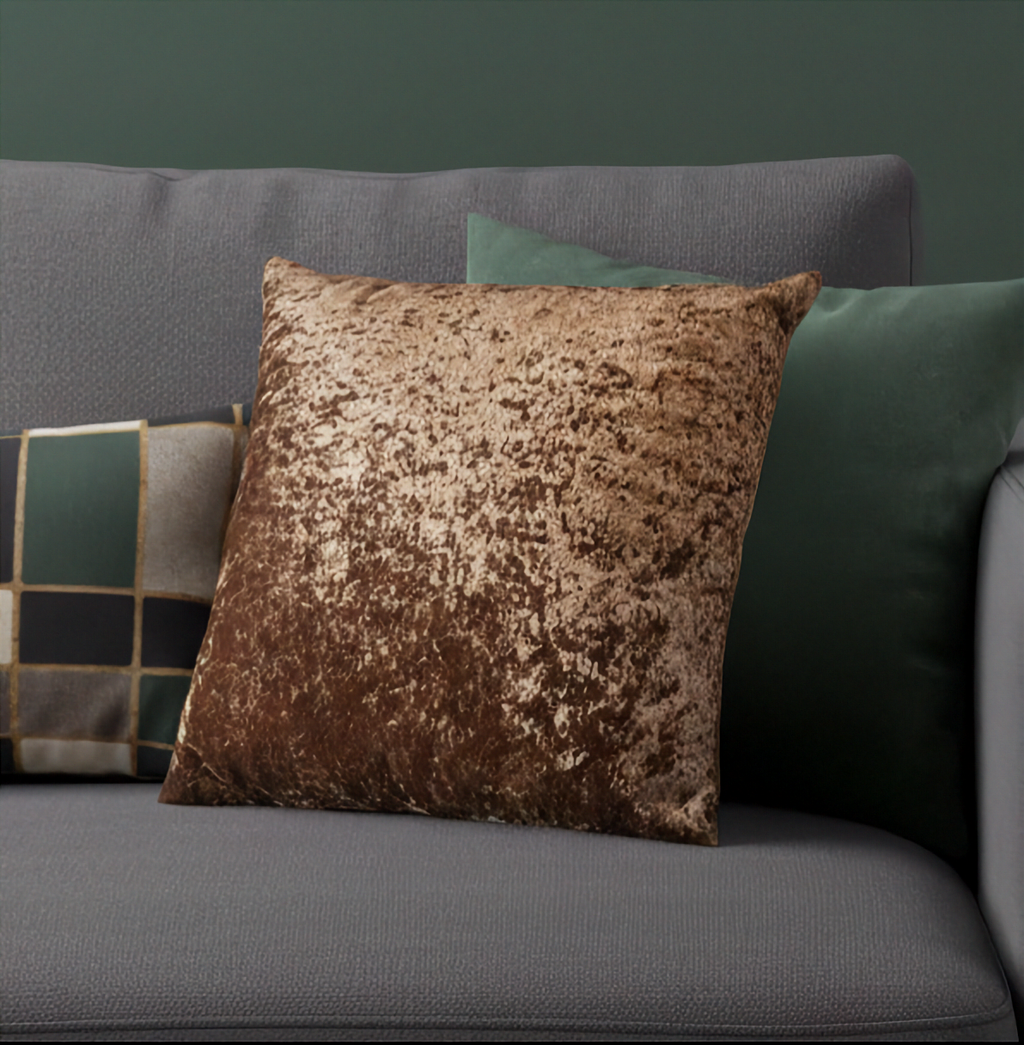 Copper Brown crushed velvet cushion on a gray sofa with green cushions.