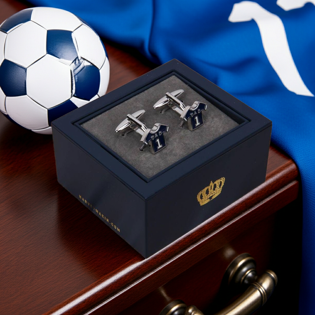 Blue sports Cufflinks in a blue gift box with a football and blue fabric in the background