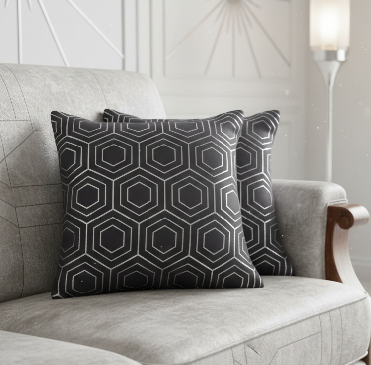 Gray geometric patterned cushions on a gray sofa in a neutral room.