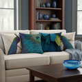 Decorative pillows with peacock designs on a beige sofa in a living room setting.