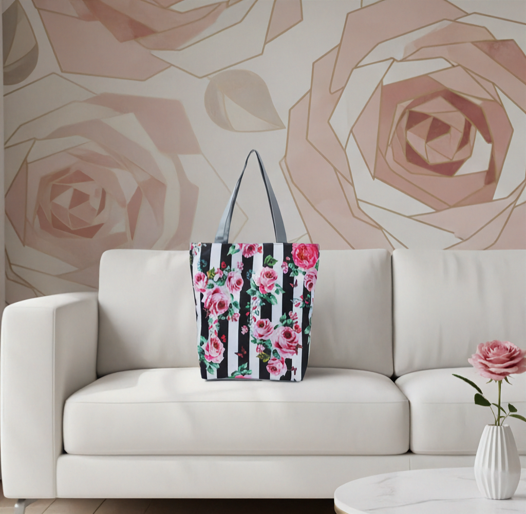 Floral tote bag on a white couch with a rose-themed wall in the background