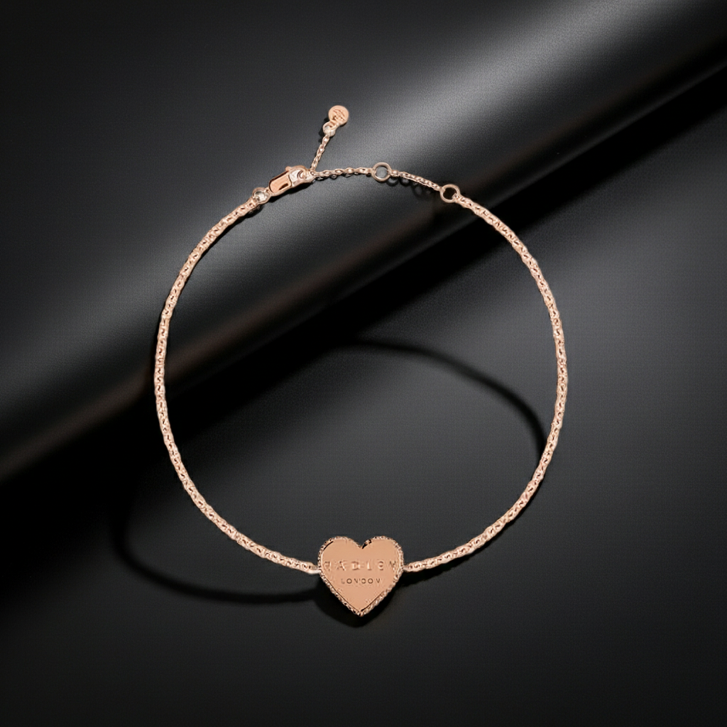 Radley rose gold bracelet with a heart-shaped tag on a dark background