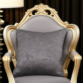 Decorative gray cushion on an ornate chair with gold accents