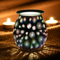 Starburst ecorative glass oil burner/ wax warmer with colorful patterns on a textured surface with candles in the background.