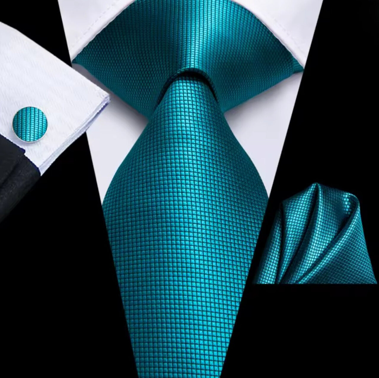 Teal tie, cufflink, and pocket square set on a white background