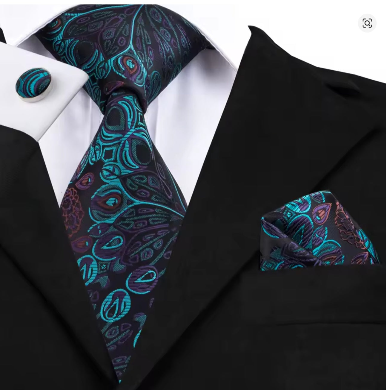 Black suit with a teal blue and purple peacock tie, pocket square, and cufflinks.