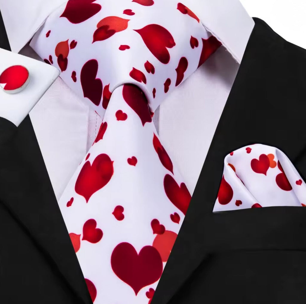 Black suit with a white shirt, red valentine heart pattern tie, and matching pocket square.