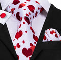 Black suit with a white shirt, red valentine heart pattern tie, and matching pocket square.