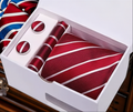 Red striped tie with matching pocket square and cufflinks in a white box.